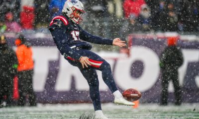 Bryce Baringer punts the ball in the middle of snow for the Patriots.