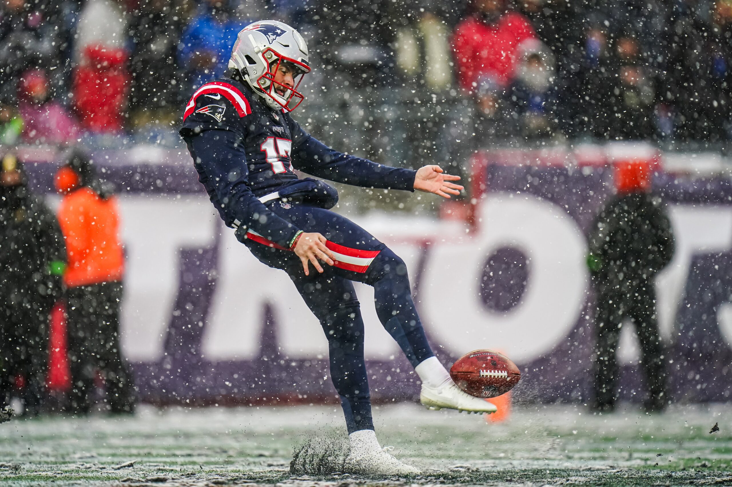 Bryce Baringer punts the ball in the middle of snow for the Patriots.