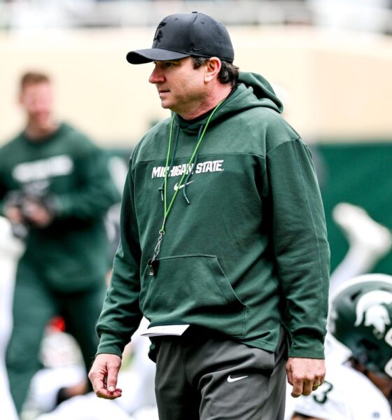 Michigan State football coach Jonathan Smith walks the field during stretches before the annual spring game.