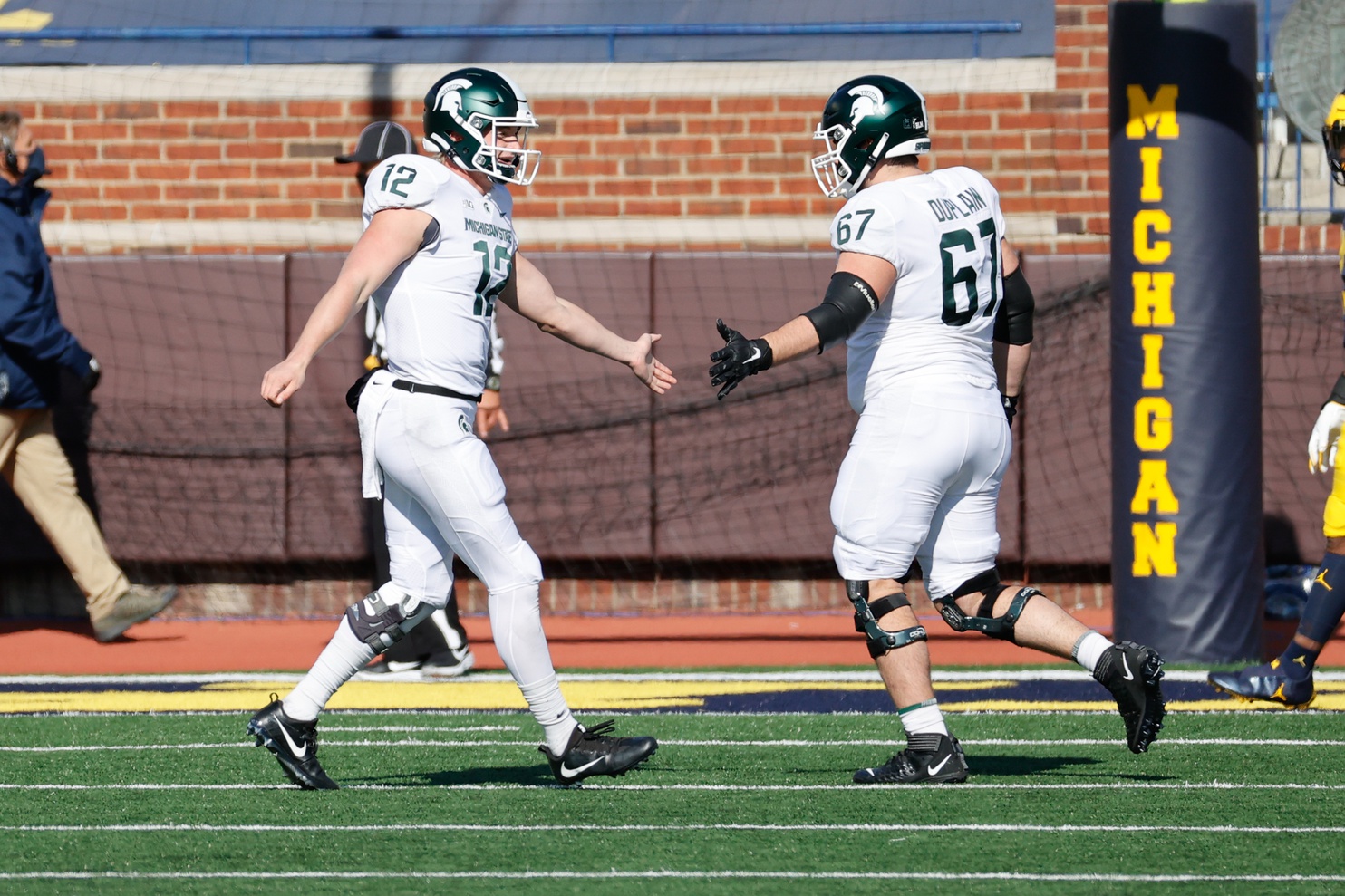 Michigan State football players Rocky Lombardi and JD Duplain slap hands during the Michigan game in 2020.