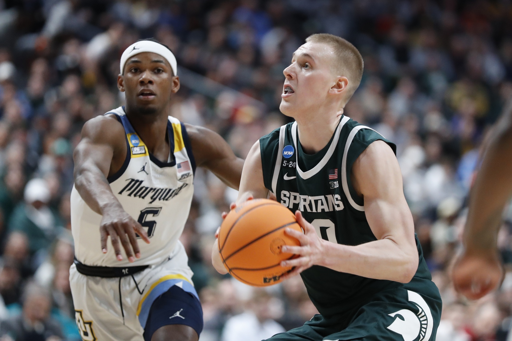 Michigan State basketball star Joey Hauser goes up for a shot against Marquette.