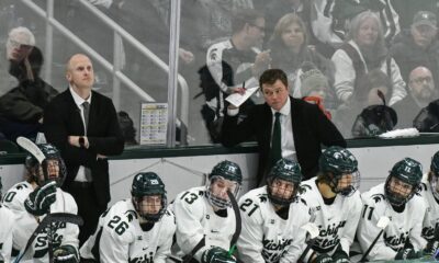 Michigan State hockey coach Adam Nightingale on the bench with his team.