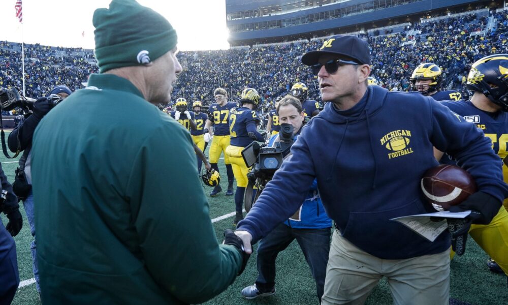 Jim Harbaugh shakes Michigan State football coach Mark Dantonio's hand.