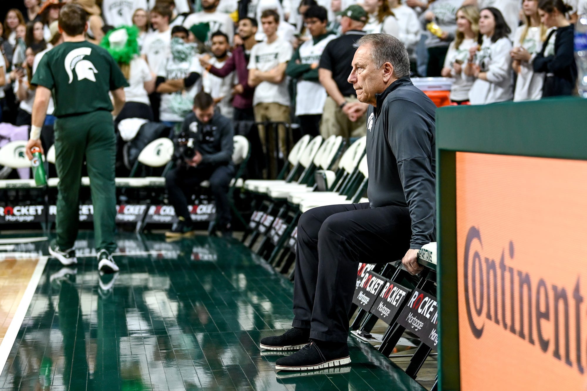 Michigan State basketball coach Tom Izzo sits on the bench before the game.