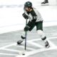 Michigan State hockey star Red Savage skates up the ice.