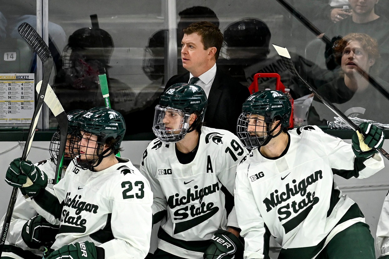 Michigan State hockey players react to a play on the bench.