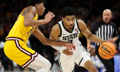 Michigan State basketball star Jaden Akins dribbles the ball against Minnesota.