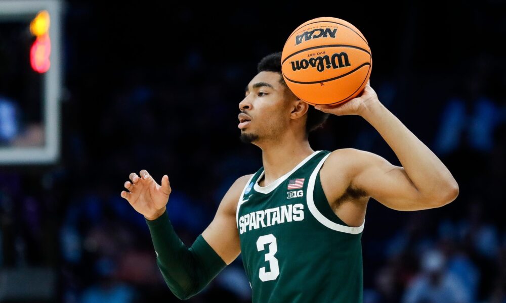 Michigan State basketball guard Jaden Akins looks to pass.