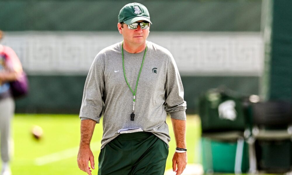 Michigan State football coach Jonathan Smith walks around during fall camp warmups.