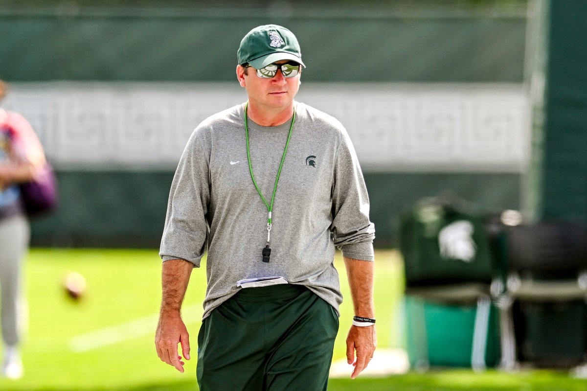 Michigan State football coach Jonathan Smith walks around during fall camp warmups.