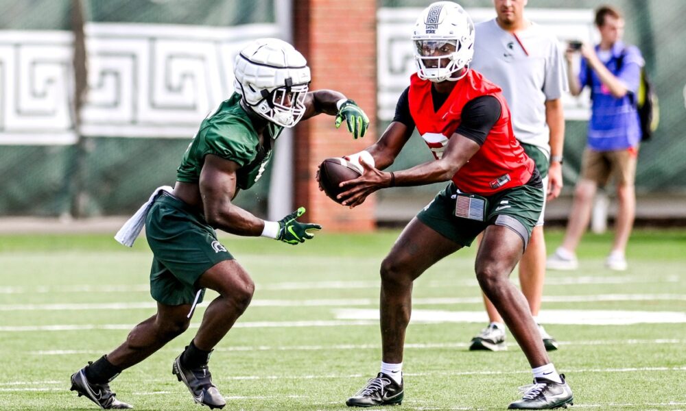 Michigan State football QB1 Aidan Chiles hands off to Nate Carter.