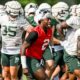 Aidan Chiles runs off the field with his Michigan State football teammates.