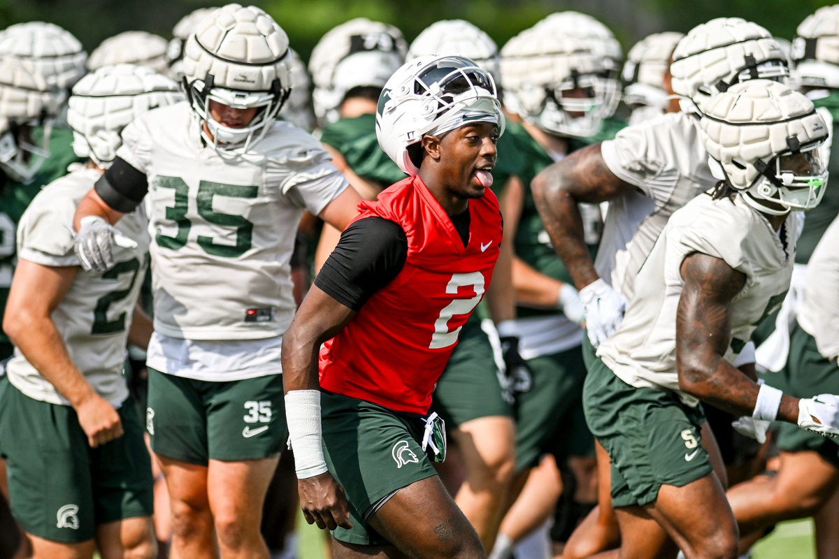 Aidan Chiles runs off the field with his Michigan State football teammates.