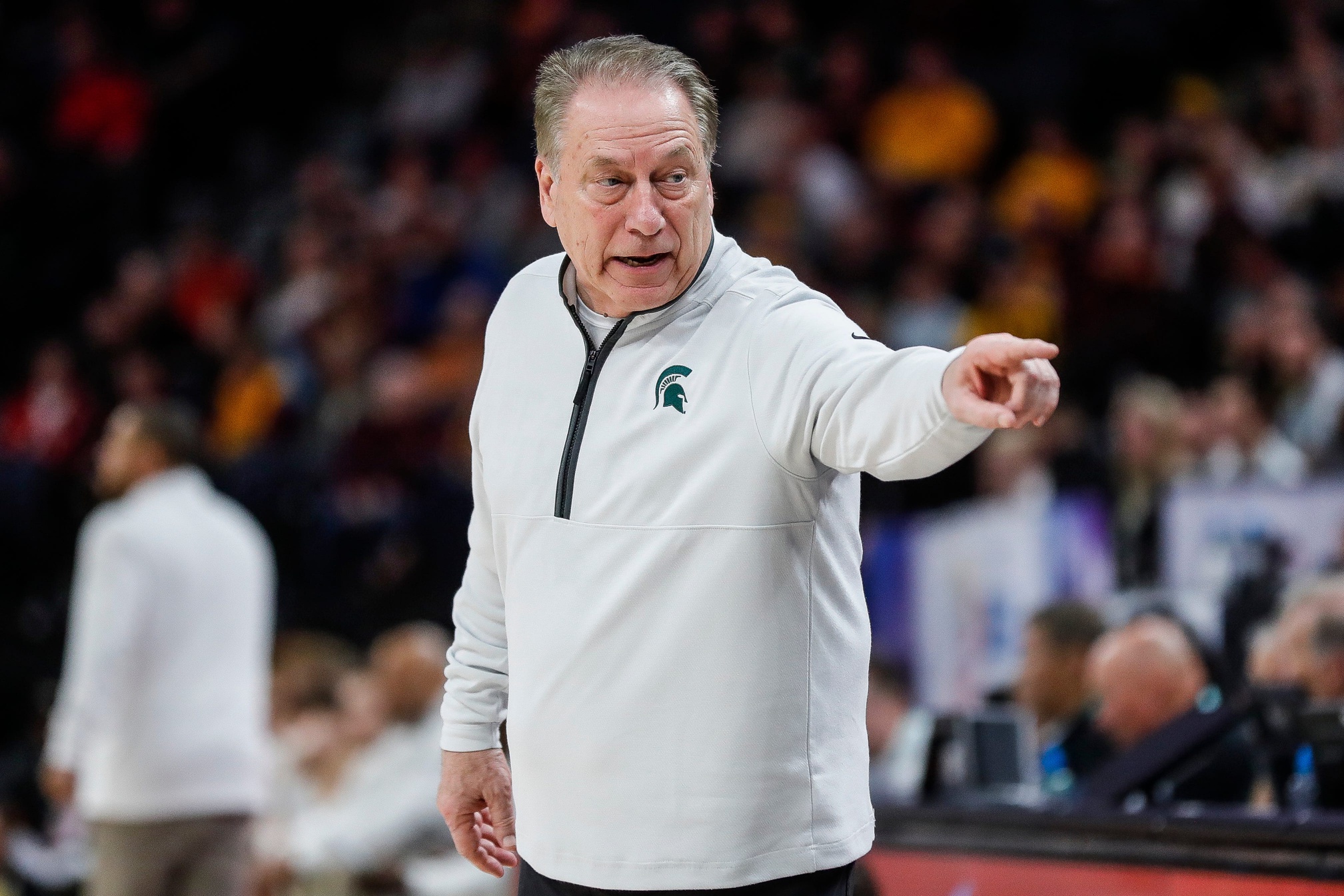 Michigan State basketball coach Tom Izzo points toward his bench.