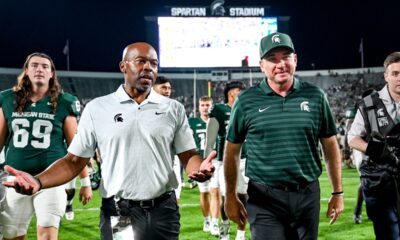 Michigan State football coach Jonathan Smith walks off the field with AD Alan Haller.