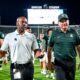 Michigan State football coach Jonathan Smith walks off the field with AD Alan Haller.