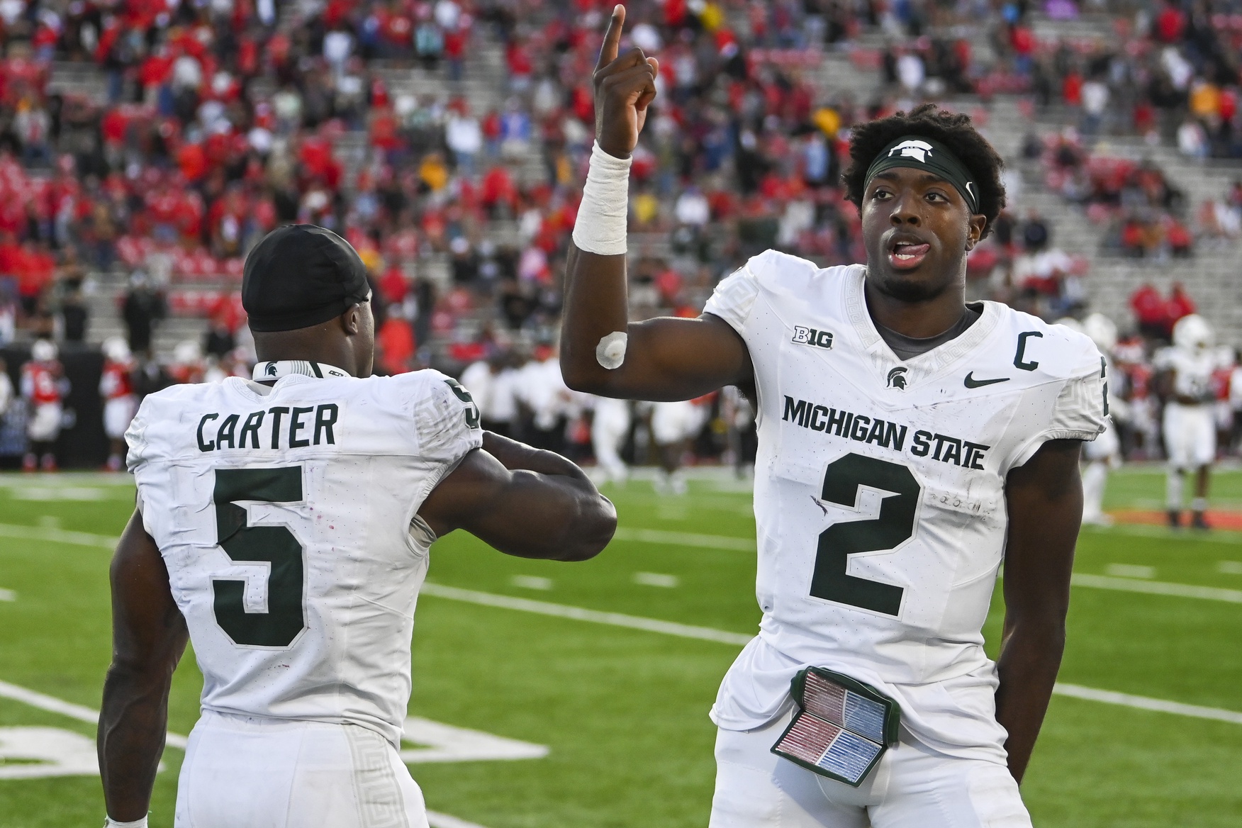 Michigan State football quarterback Aidan Chiles and running back Nate Carter celebrate a win.