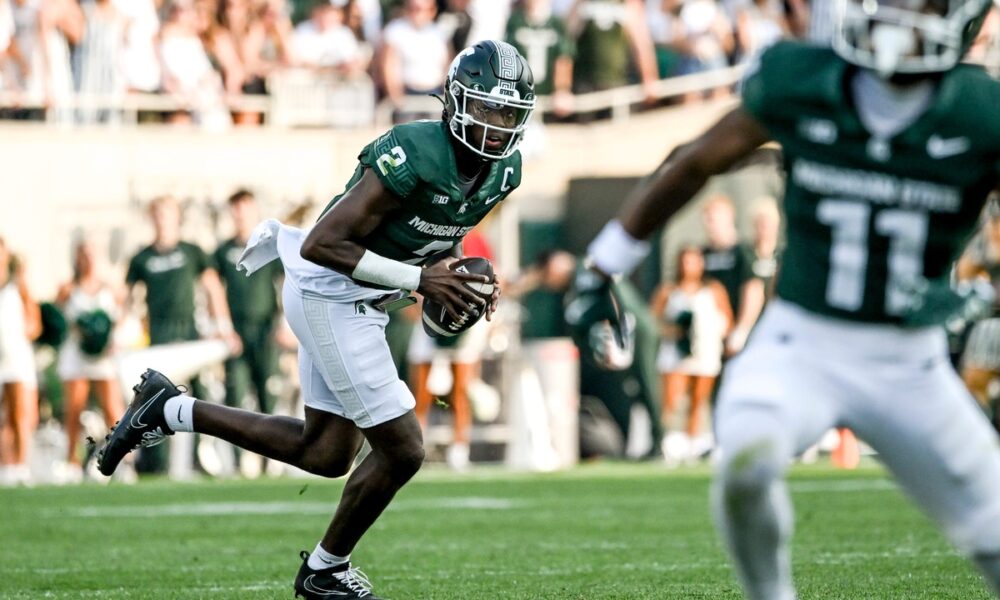 Michigan State football quarterback Aidan Chiles rolls out to pass.