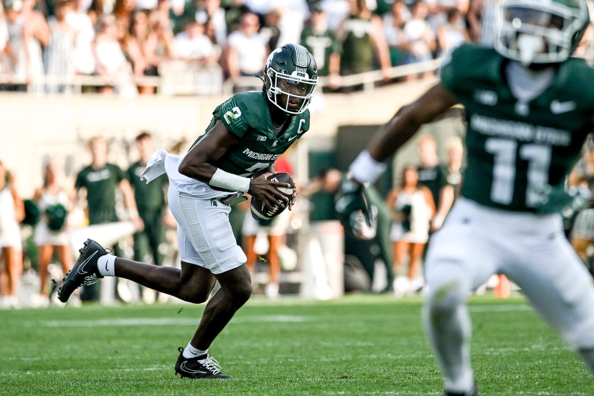 Michigan State football quarterback Aidan Chiles rolls out to pass.