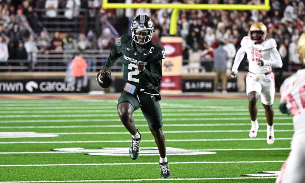 Michigan State football star Aidan Chiles runs with the ball.