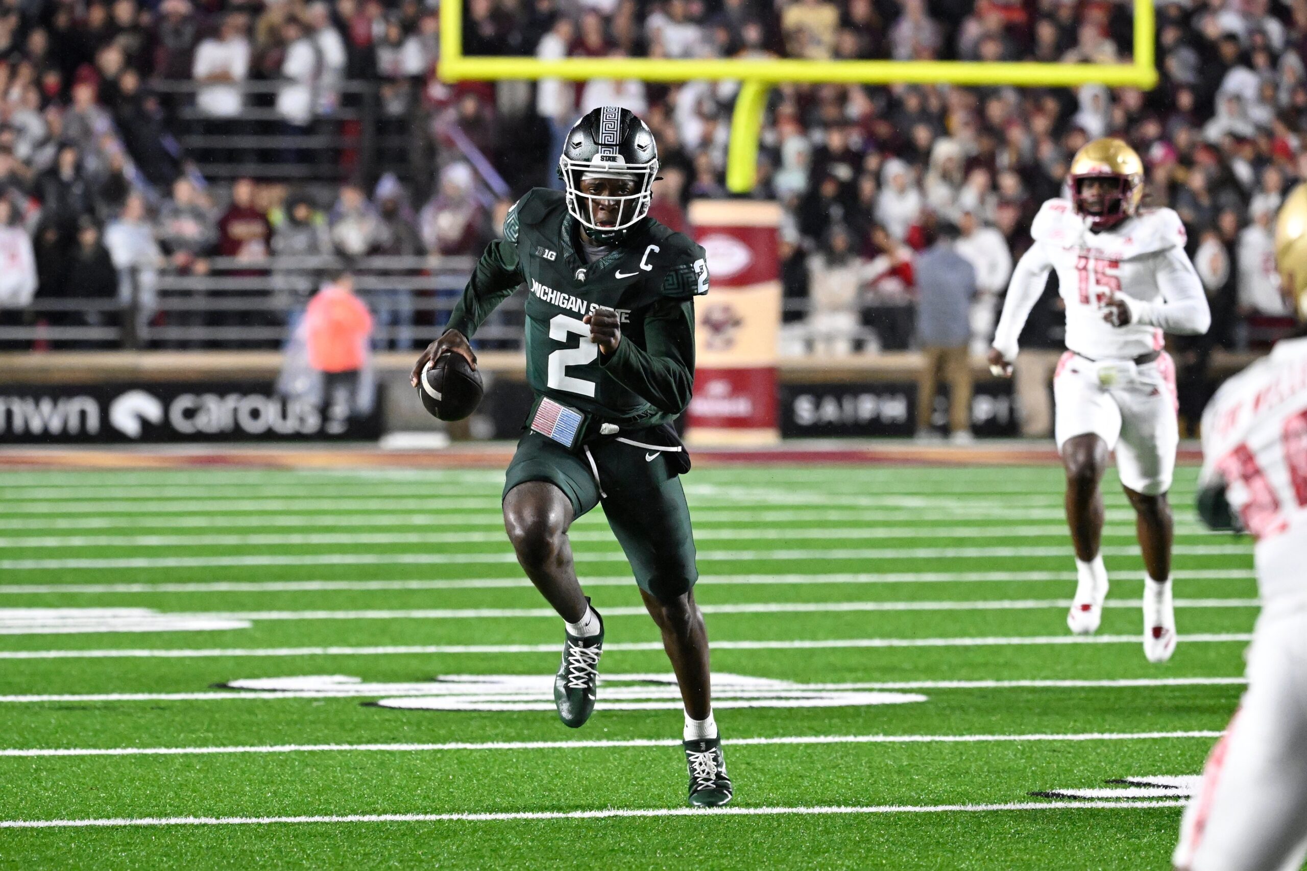 Michigan State football star Aidan Chiles runs with the ball.