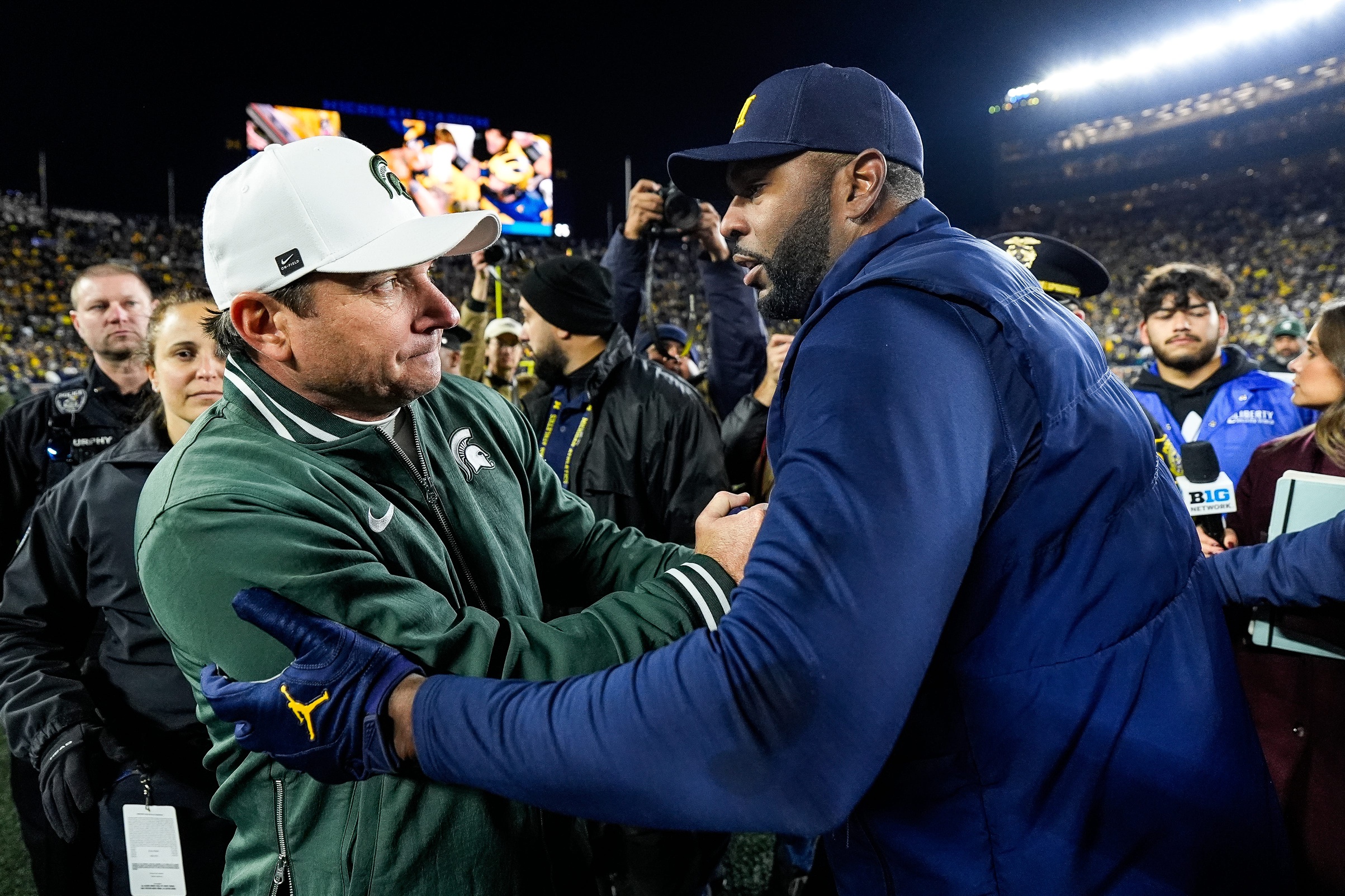 Michigan State football coach Jonathan Smith shakes Sherrone Moore's hand.